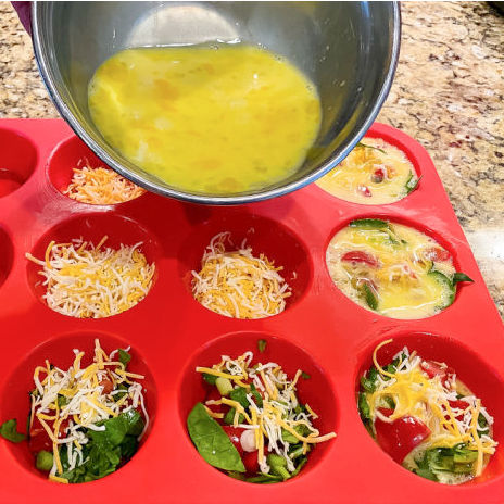 Pouring eggs into a red silicone pan