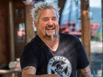 Guy Fieri smiling in a restaurant