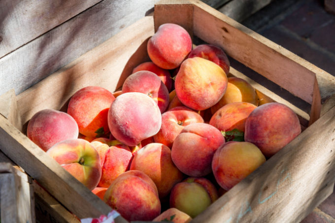 Wooden crate filled with fresh picked peaches